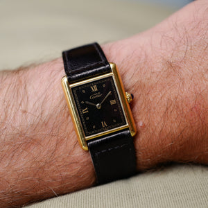 Café noir les montres Cartier Must Tank grand modèle noir 1990