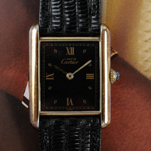 Café noir les montres Cartier Must Tank grand modèle noir 1990