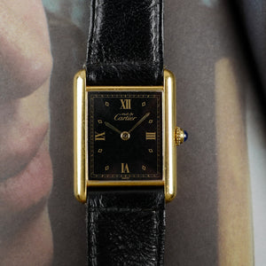 Café noir les montres Cartier Must Tank grand modèle noir 1990