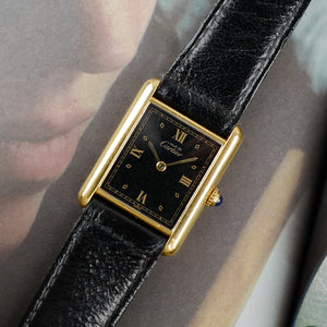 Café noir les montres Cartier Must Tank grand modèle noir 1990