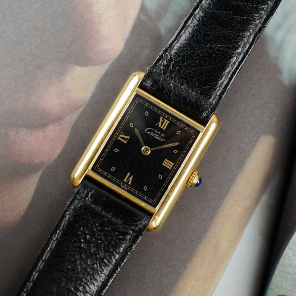 Café noir les montres Cartier Must Tank grand modèle noir 1990