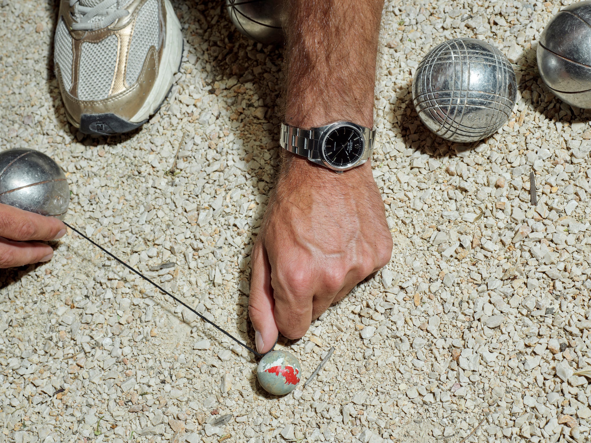 Rolex vintage au poignet, partie de pétanque