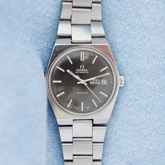 Jolie montre Omega vintage bracelet acier cadran noir gris